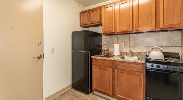 The front door and kitchenette in a model studio apartment at Skyline Tower Senior Apartments
