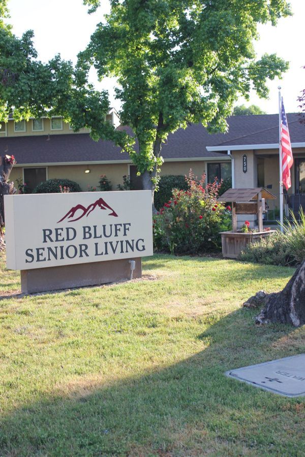 Welcome sign and American flag in front of Red Bluff Senior Living