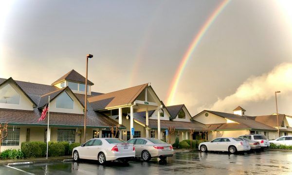 Rainbow setting behind the Summerfield Senior Living building front