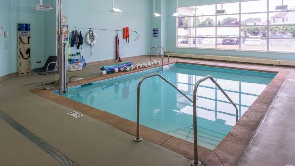 Kingston Care Center of Sylvania's indoor therapy pool, with foam weights and pool noodles at one edge