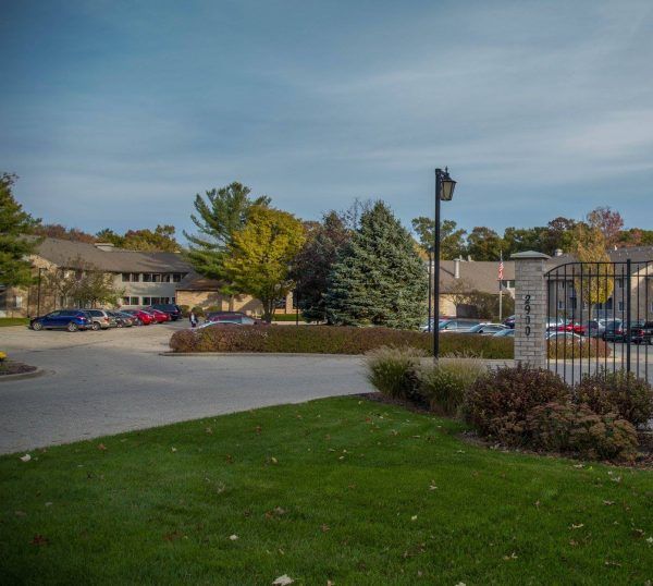 The entrance to Sentinel Pointe Retirement Community, showing the parking lot and the building front