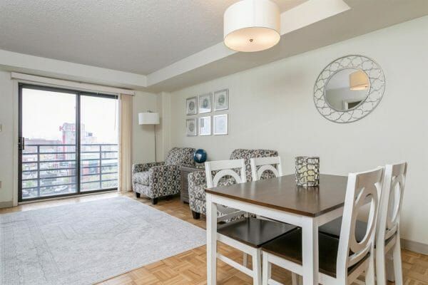Harbour View Senior Living Community's model apartment living room and dining area, and sliding glass door onto a balcony