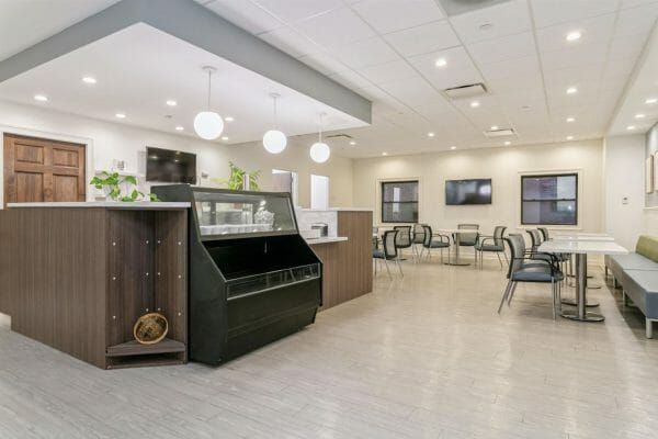A counter, food case, and tables in Harbour View Senior Living Community's bistro