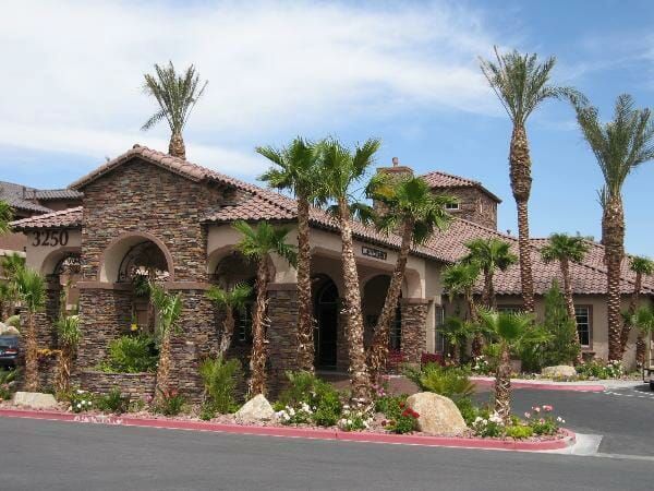 Carefree Senior Living at The Willows' stone and stucco building front, with palm trees around the entrance