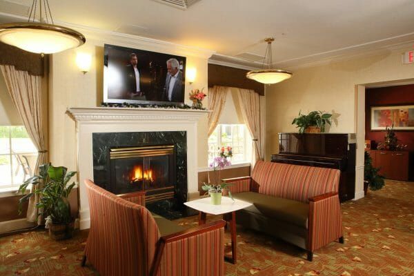 Monmouth Crossing Assisted Living's fireside lounge and tv area