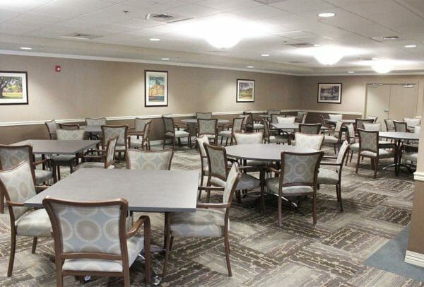 Heritage Run at Stadium Place community gathering room with tables in chairs in gray and brown